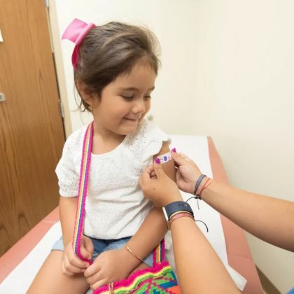 Toddler getting an immunisation needle smiling