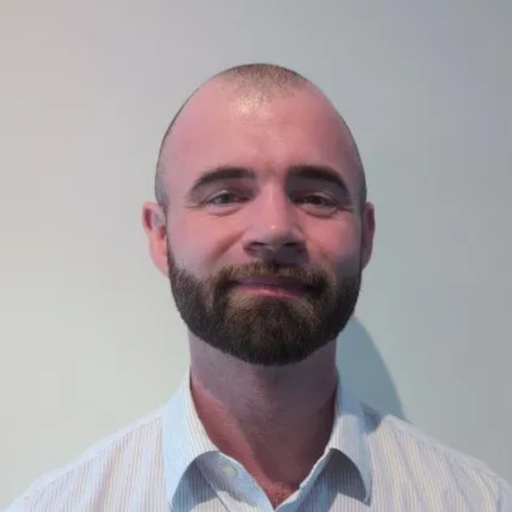 Dr Sam McTigue smiles at the camera.