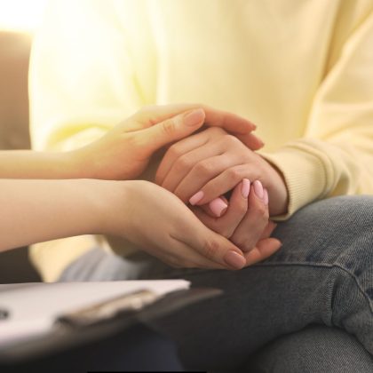 close up of two person holding each others hands in a ball